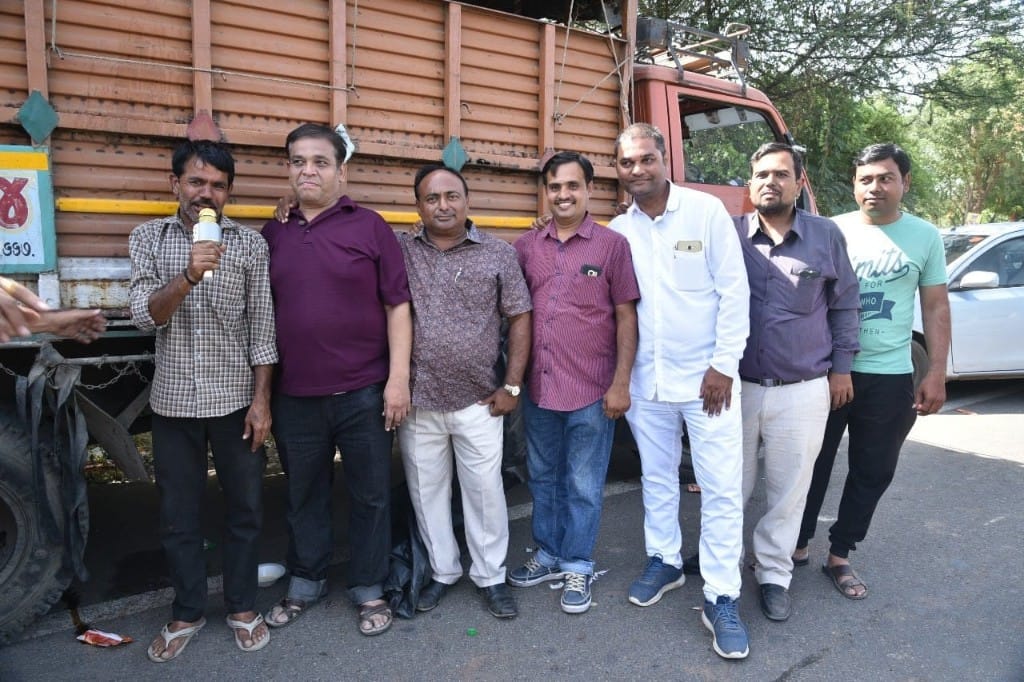 Navchetna Charitable Trust volunteers standing in front of a cargo truck during food distribution in Ambaji