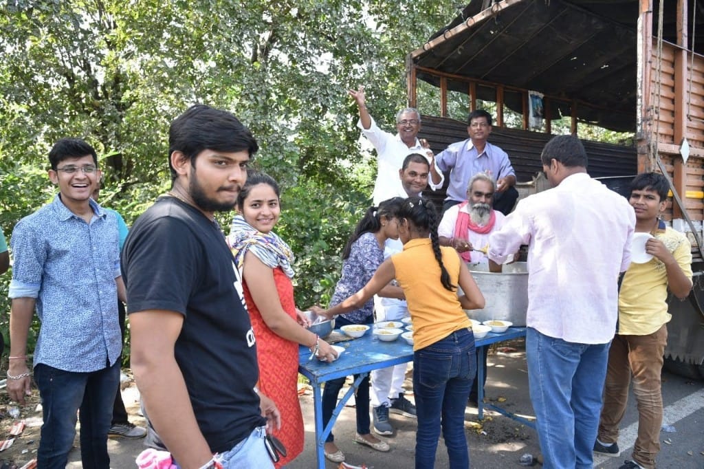Volunteers distributing freshly prepared food from a truck during Ambaji food seva